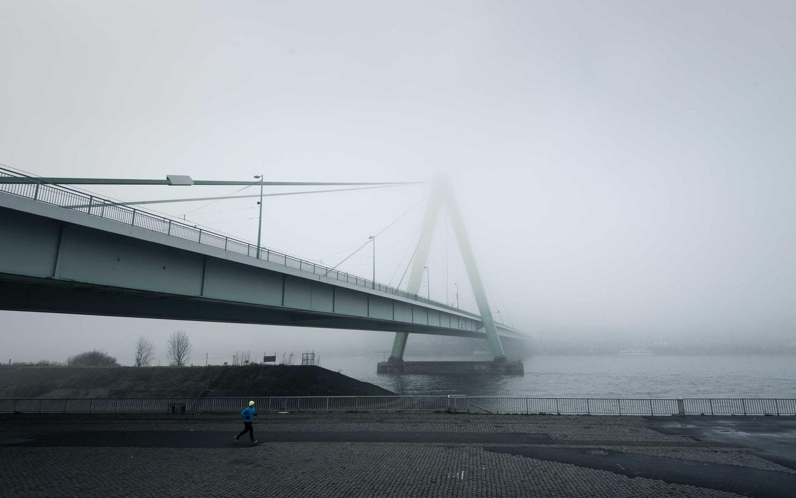 A long bridge disappearing into grey fog